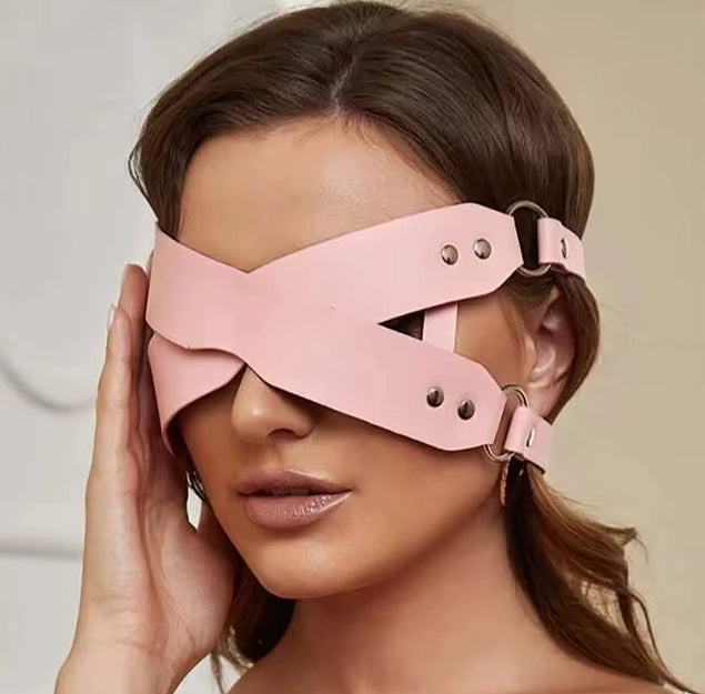 Front view of a woman wearing a pink leather BDSM blindfold, showcasing its elegant design.